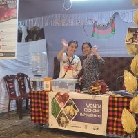 two girls in an exhibition stall waving